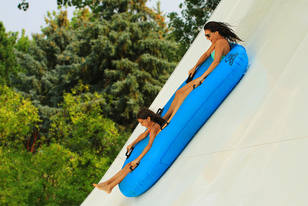 Zoomerang attraction, mother and daughter sliding on water tube, water world